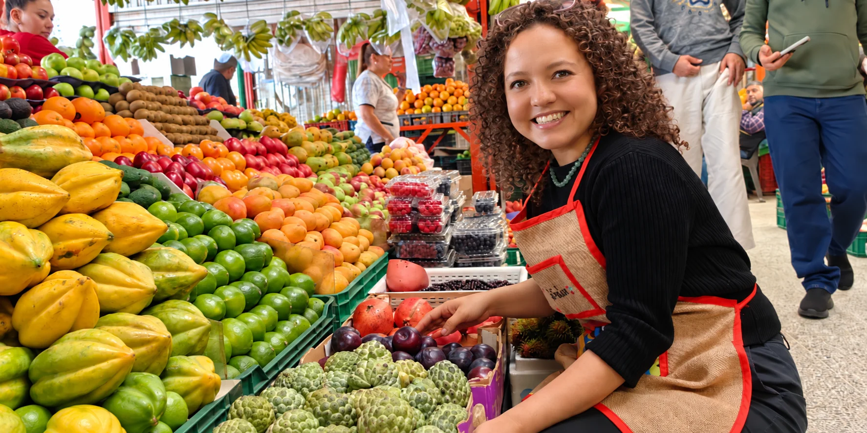 Founder of 321 Colombia surrounded by fruit at Paloquemao Market